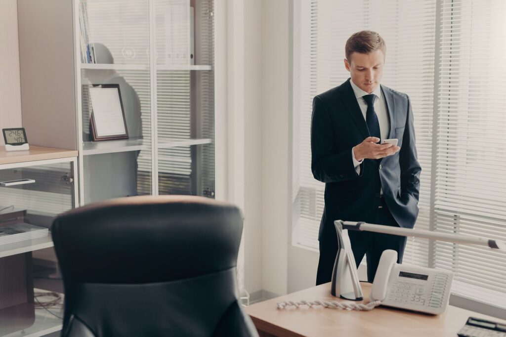 Man in a suit using his smartphone at the office