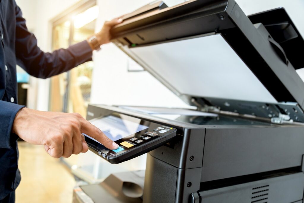 A man using a scanning and faxing machine