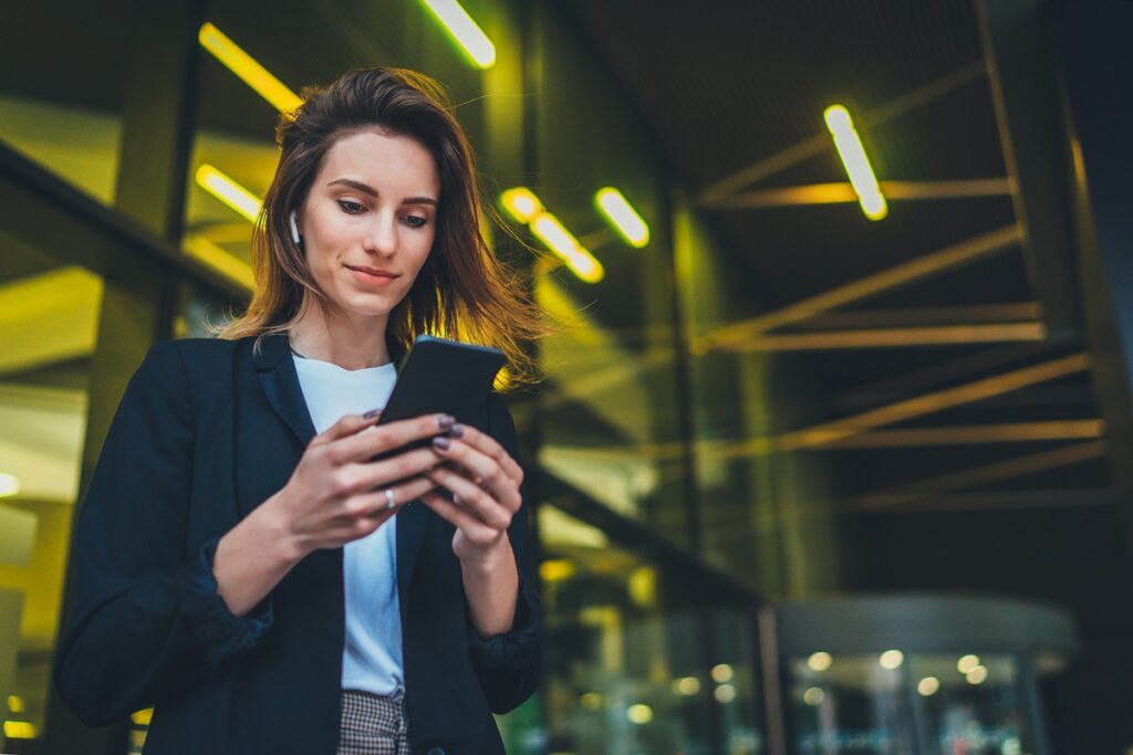 A woman faxing from her smartphone outside